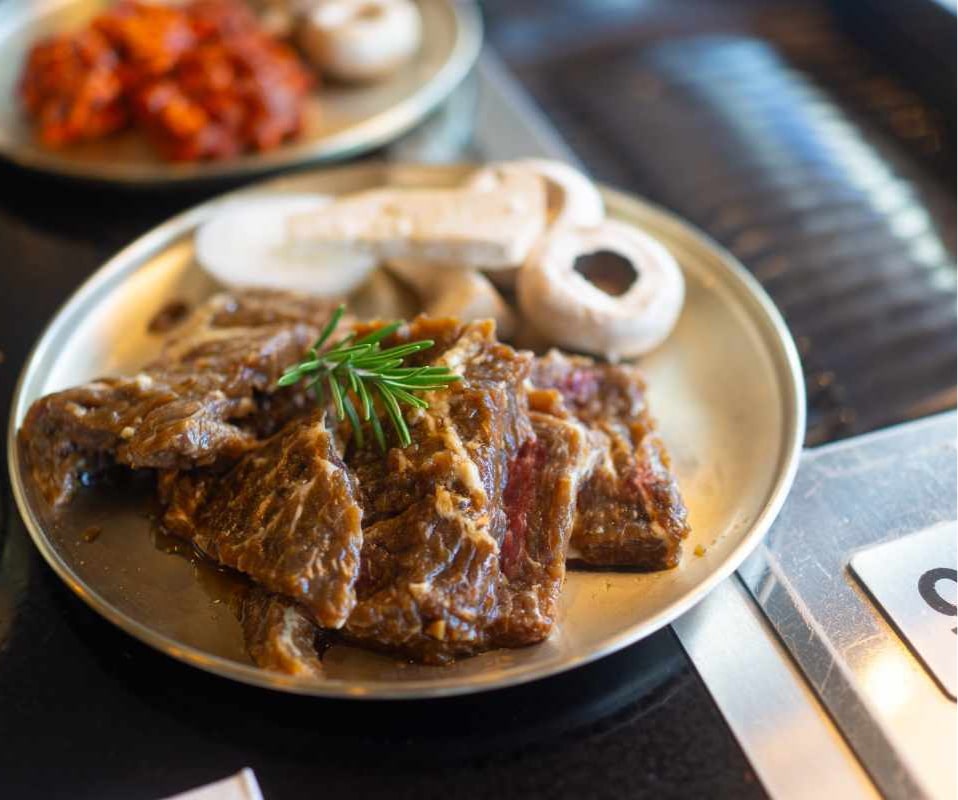 Marinated Korean BBQ beef and mushrooms served on a plate at Geonbae Frankston VIC