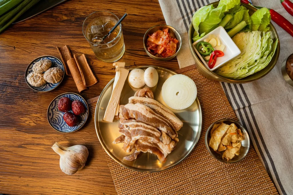 Sliced Korean pork belly with lettuce wraps, garlic, and kimchi at Geonbae Frankston VIC